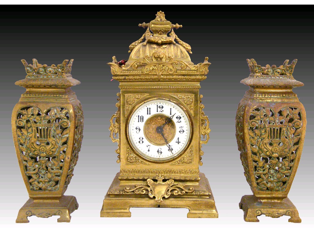 Appraisal: Brass mantel clock garniture the cream chapter ring enclosing a