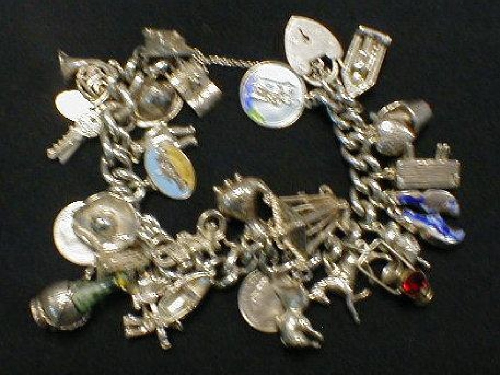 Appraisal: A silver curb link charm bracelet twenty eight approx charms