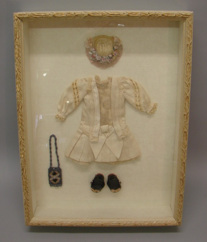 Appraisal: Framed outfit for a bisque doll Reproduction ecru silk drop