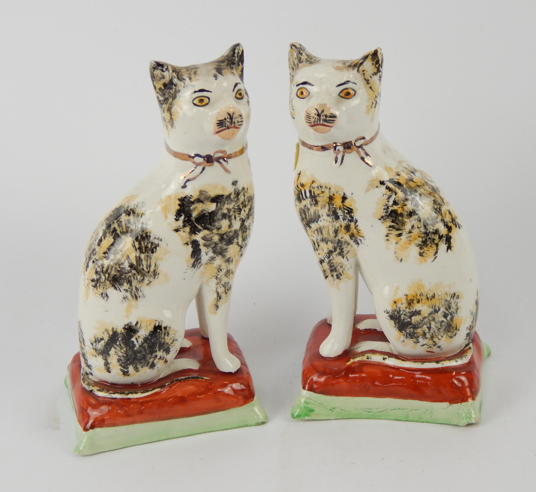 Appraisal: A pair of Staffordshire style cats upon plinths with gilt