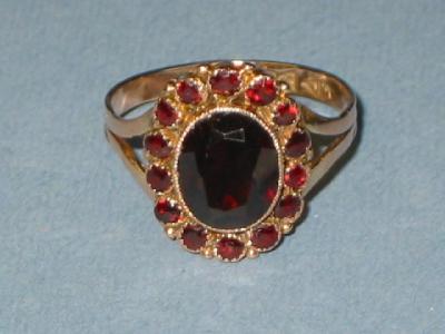 Appraisal: A GARNET DRESS RING the oval central stone set in