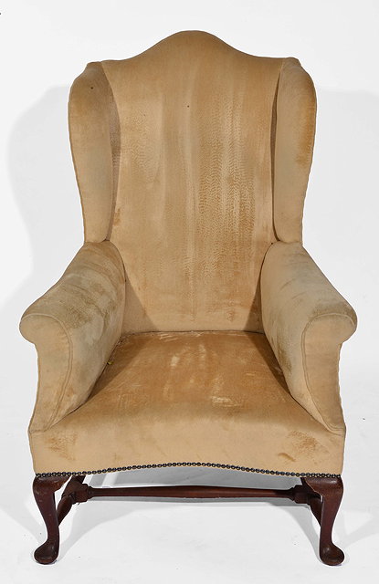 Appraisal: A CREAM UPHOLSTERED WING BACK ARMCHAIR the short cabriole front