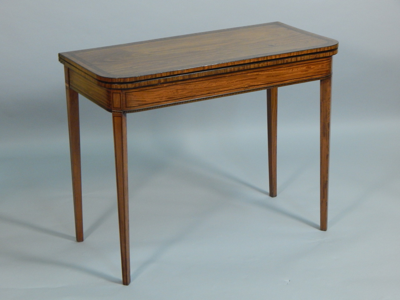 Appraisal: A thC satinwood and burr walnut cross banded card table