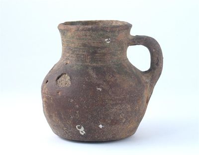 Appraisal: A medieval pottery mug with incised bands around the neck