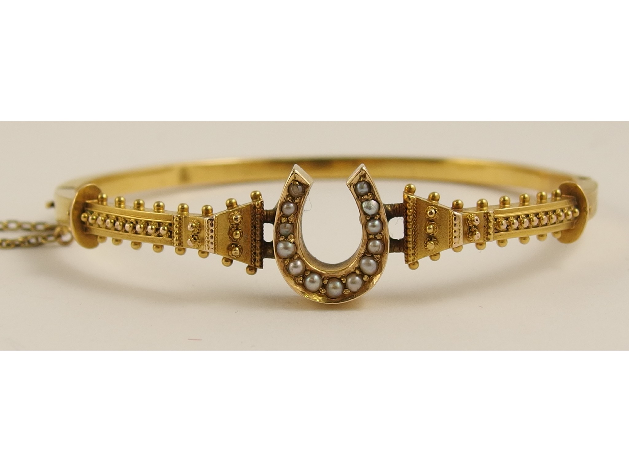 Appraisal: A Victorian yellow metal horseshoe detailed bangle with granulation and