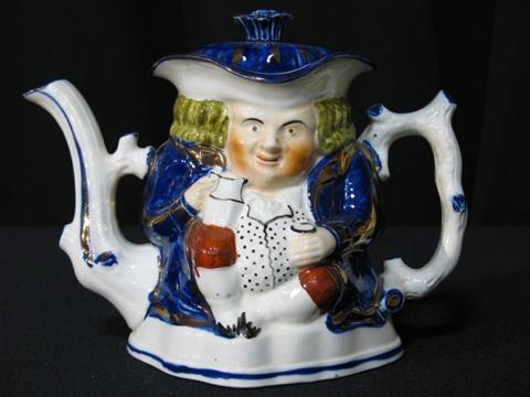 Appraisal: ENGLISH CHARACTER TEAPOT Molded as a drinker seated with a