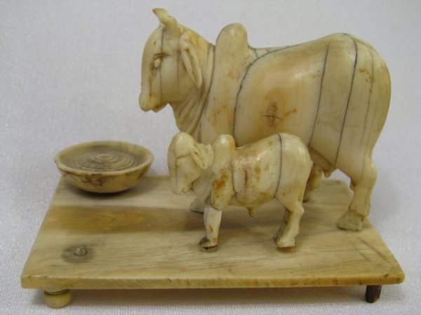 Appraisal: Miniature carved Brahmin type cow with calf and bowl on