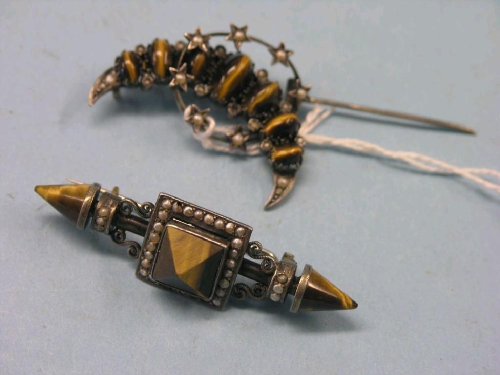 Appraisal: A tiger's eye and white metal crescent brooch and a