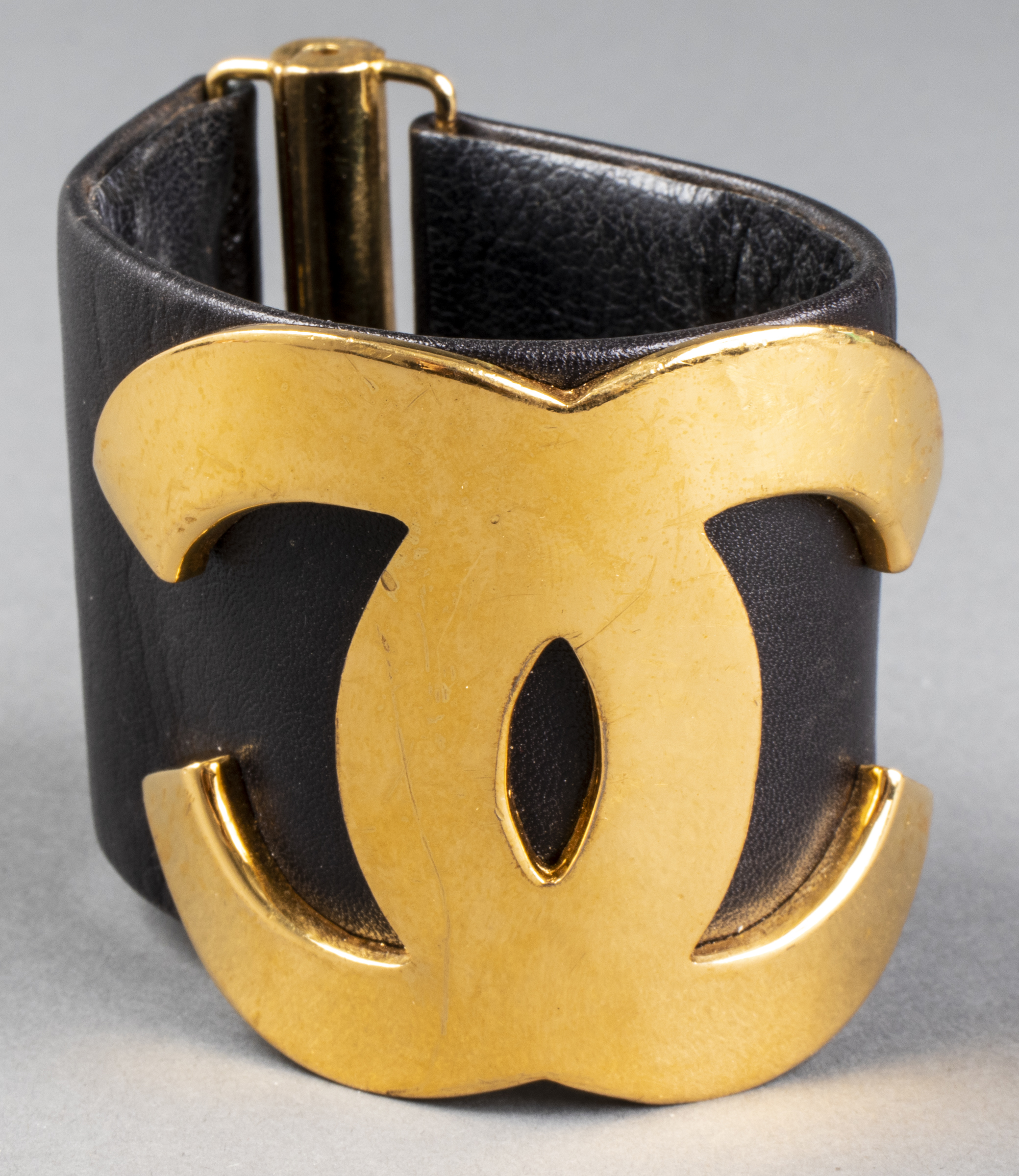 Appraisal: CHANEL LEATHER GOLD-TONE LOGO BRACELET C Chanel Runway oversized black