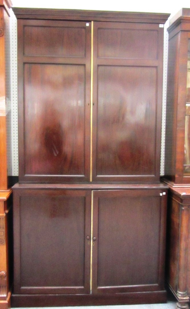 Appraisal: A Regency brass mounted double height mahogany cupboard on plinth