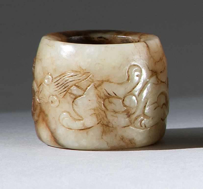 Appraisal: BROWN AND WHITE JADE THUMB RING th CenturyWith relief dragon