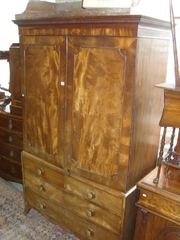 Appraisal: A Georgian mahogany linen press the upper section fitted with