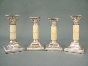 Appraisal: A pair of silver candlesticks with reeded ivory columnar supports