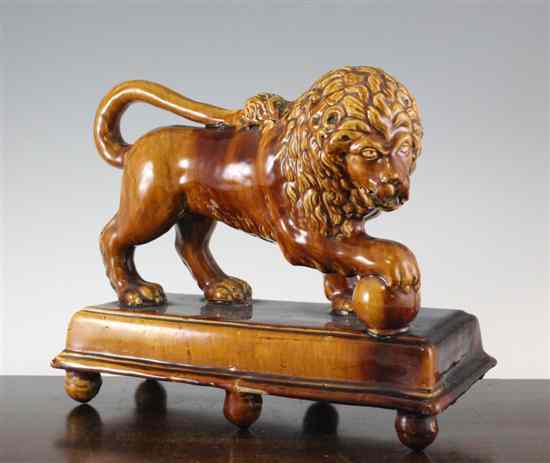 Appraisal: An unusual treacle glazed earthenware figure of a lion c