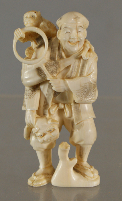 Appraisal: Carved ivory figure of a man with monkey holding ring