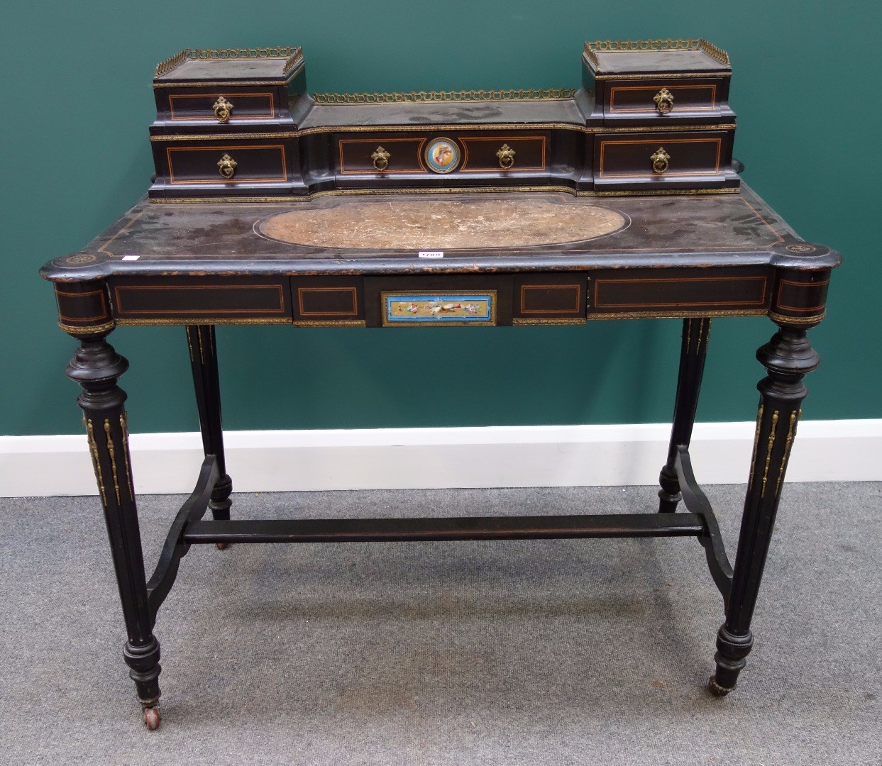 Appraisal: A Victorian gilt metal mounted ebonised writing desk with ceramic