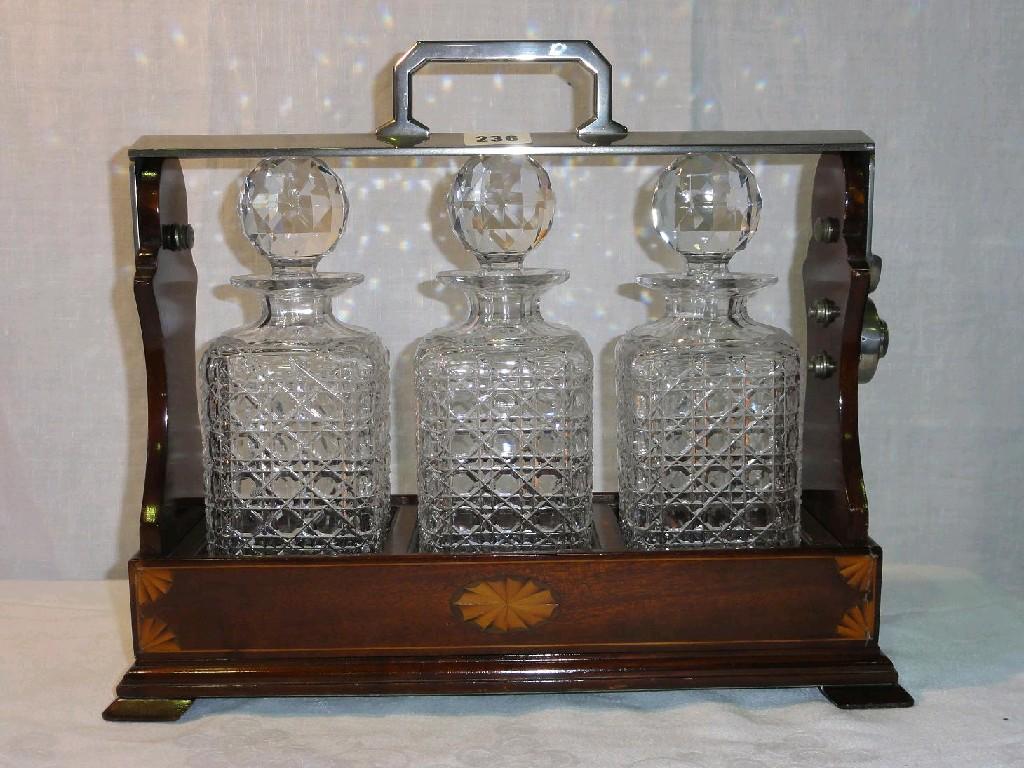 Appraisal: A mahogany tantalus with inlaid paterae decoration and with plated