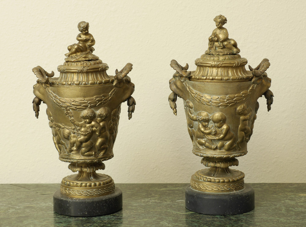 Appraisal: PAIR CONTINENTAL FIGURAL PUTTI CAST BRONZE COVERED URNS Matched pair