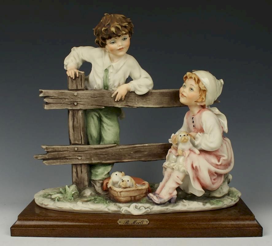 Appraisal: Capodimonte Bruno Merli Figurine Boy and Girl with Puppies MANUFACTURE