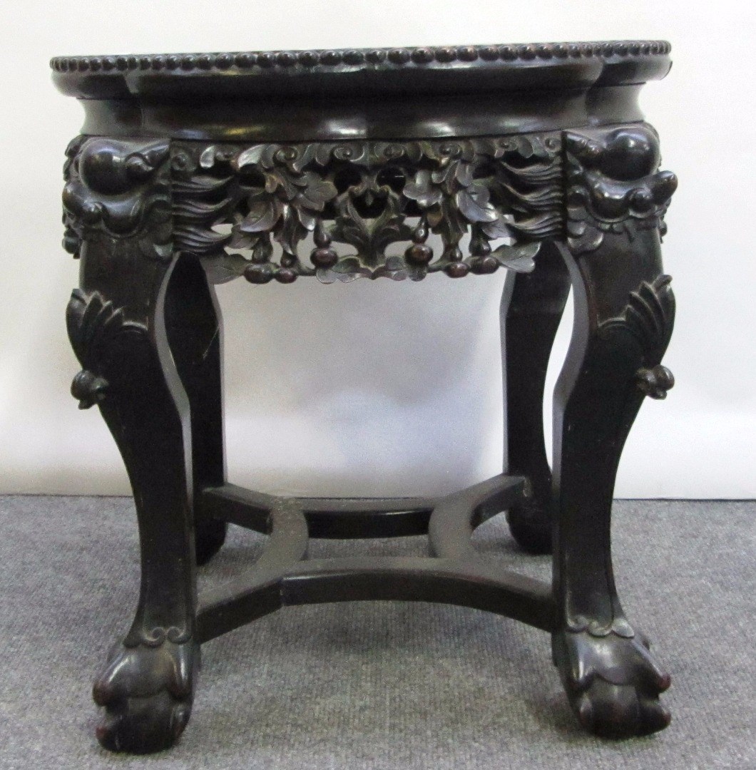 Appraisal: An early th century profusely carved hardwood urn stand with