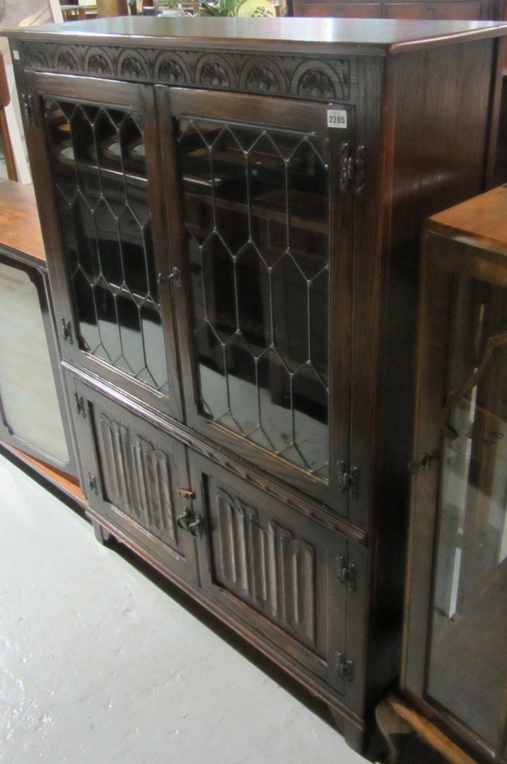 Appraisal: An oak display cabinet with astragal glazed doors and linen