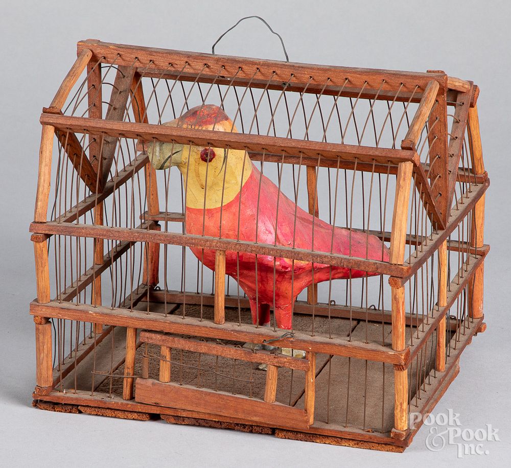 Appraisal: Composition parrot in a wire and wood cage Composition parrot