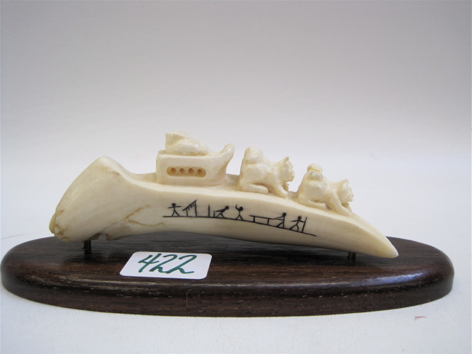 Appraisal: INNUIT CARVED WALRUS IVORY of a dog sledding scene mounted