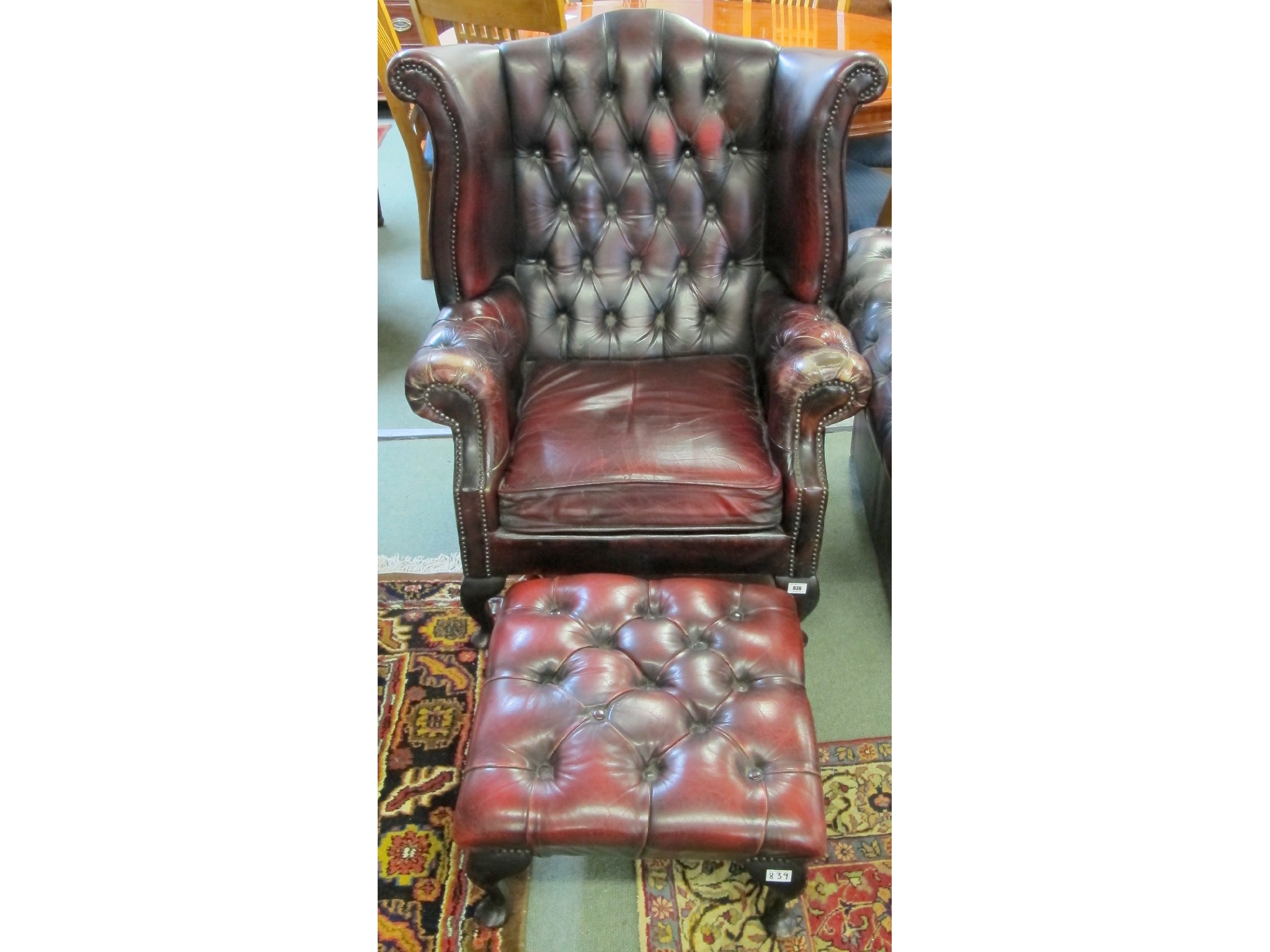 Appraisal: A red leather wing back Chesterfield chair and foot stool