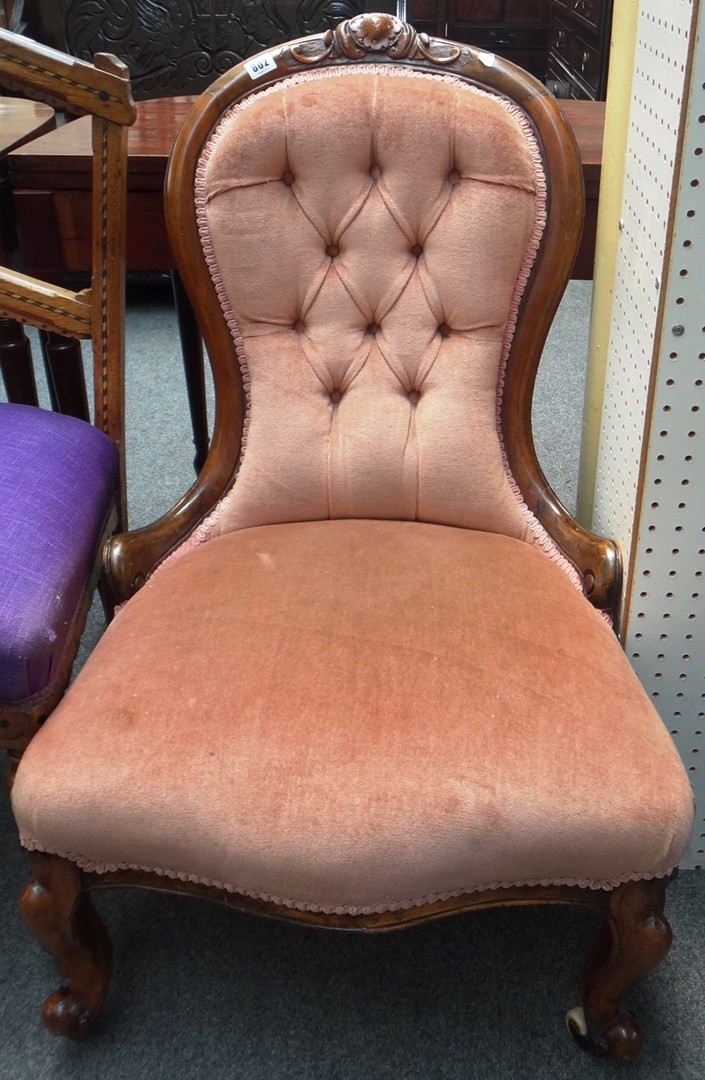 Appraisal: A Victorian walnut framed armchair with serpentine seat and scroll