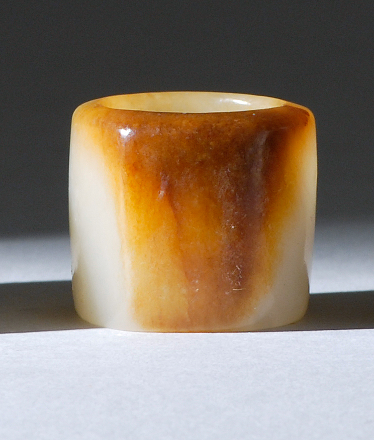 Appraisal: WHITE AND RUSSET JADE ARCHER'S RING th CenturyWith flattened russet