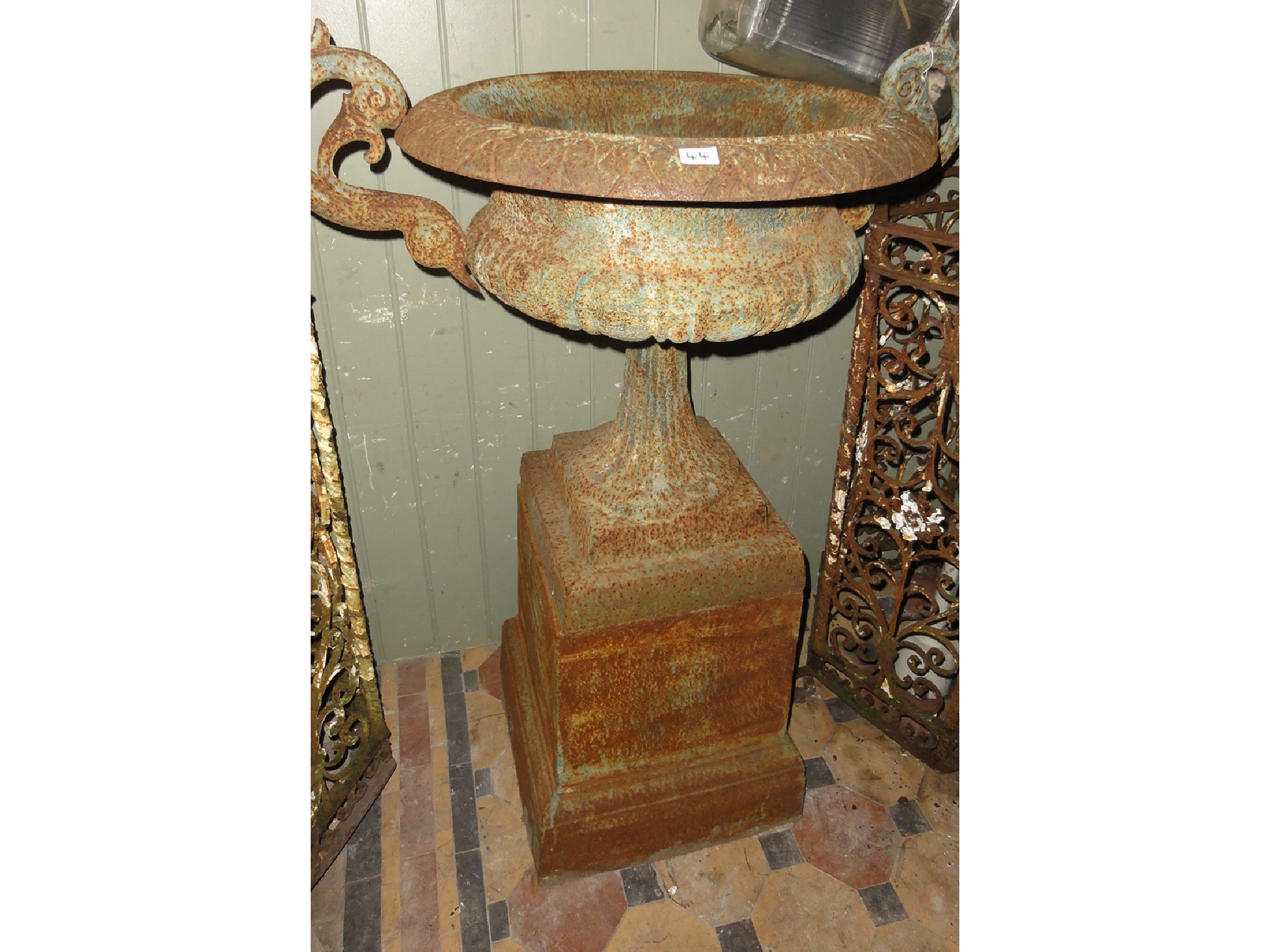 Appraisal: A weathered reproduction cast iron campana trophy shaped garden urn