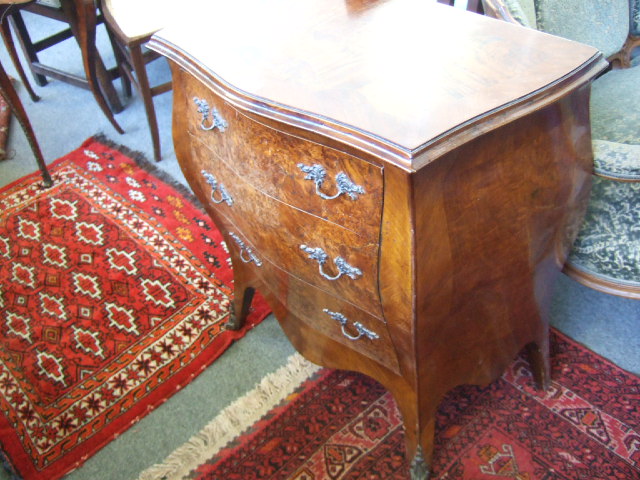 Appraisal: A mid th century Continental style walnut bombe shaped commode