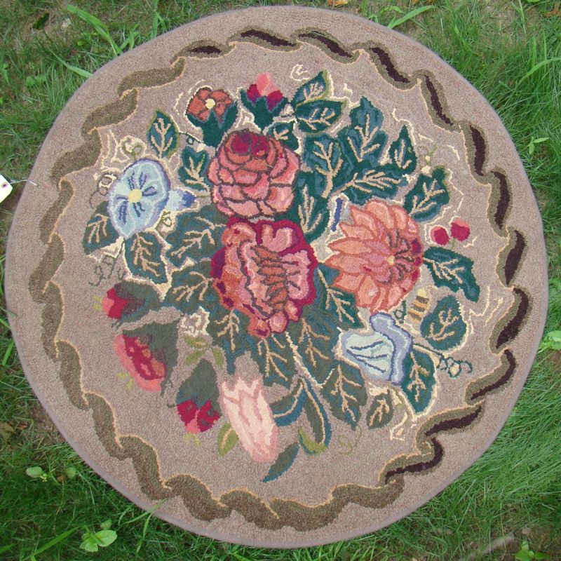 Appraisal: HOOKED RUG Diameter Central floral bouquet surrounded by a scrolling