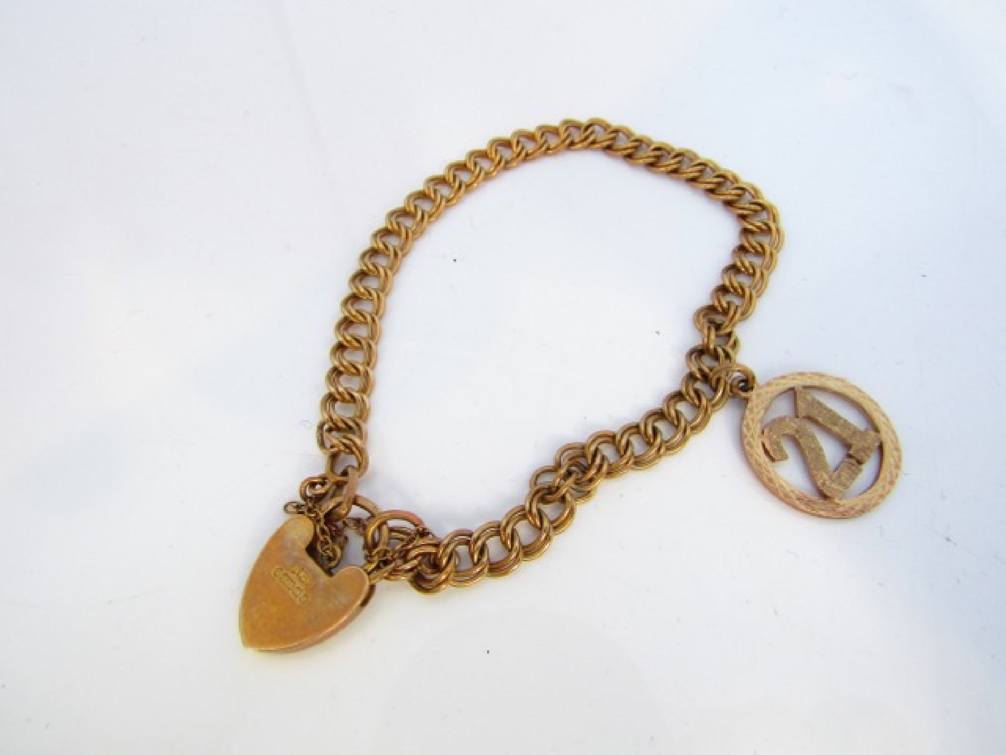 Appraisal: A ct gold double curb-link bracelet with heart-shaped padlock clasp