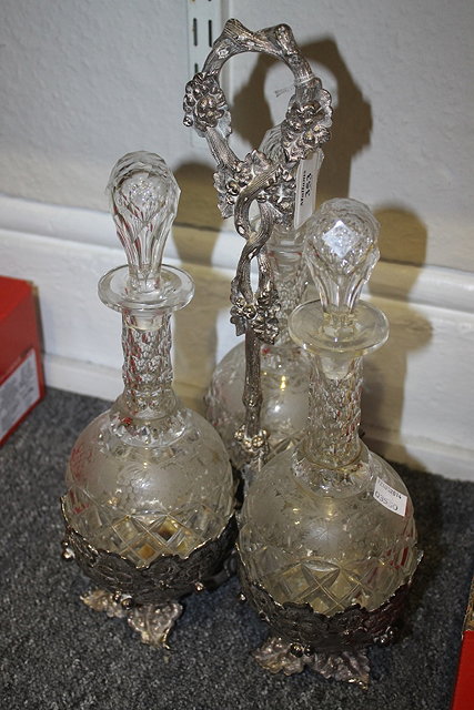 Appraisal: A VICTORIAN SILVER PLATED THREE BOTTLE TANTALUS with relief grapevine