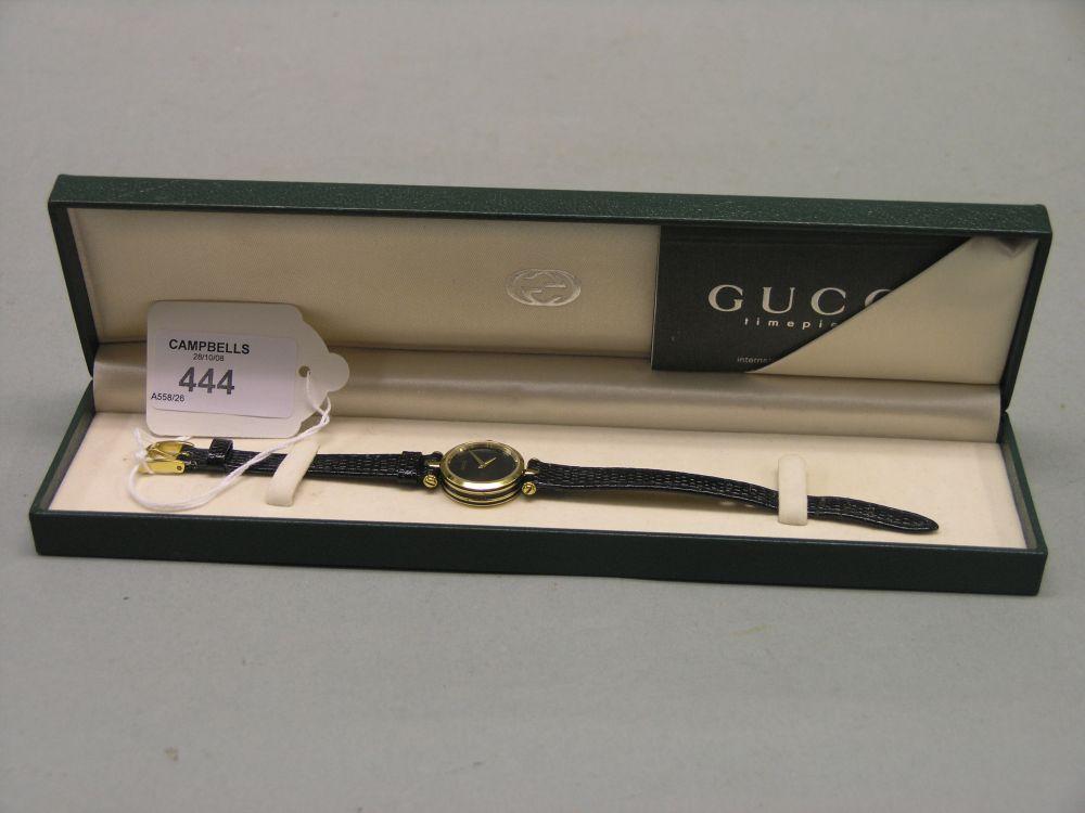 Appraisal: A lady's Gucci wristwatch with plain black dial leather strap