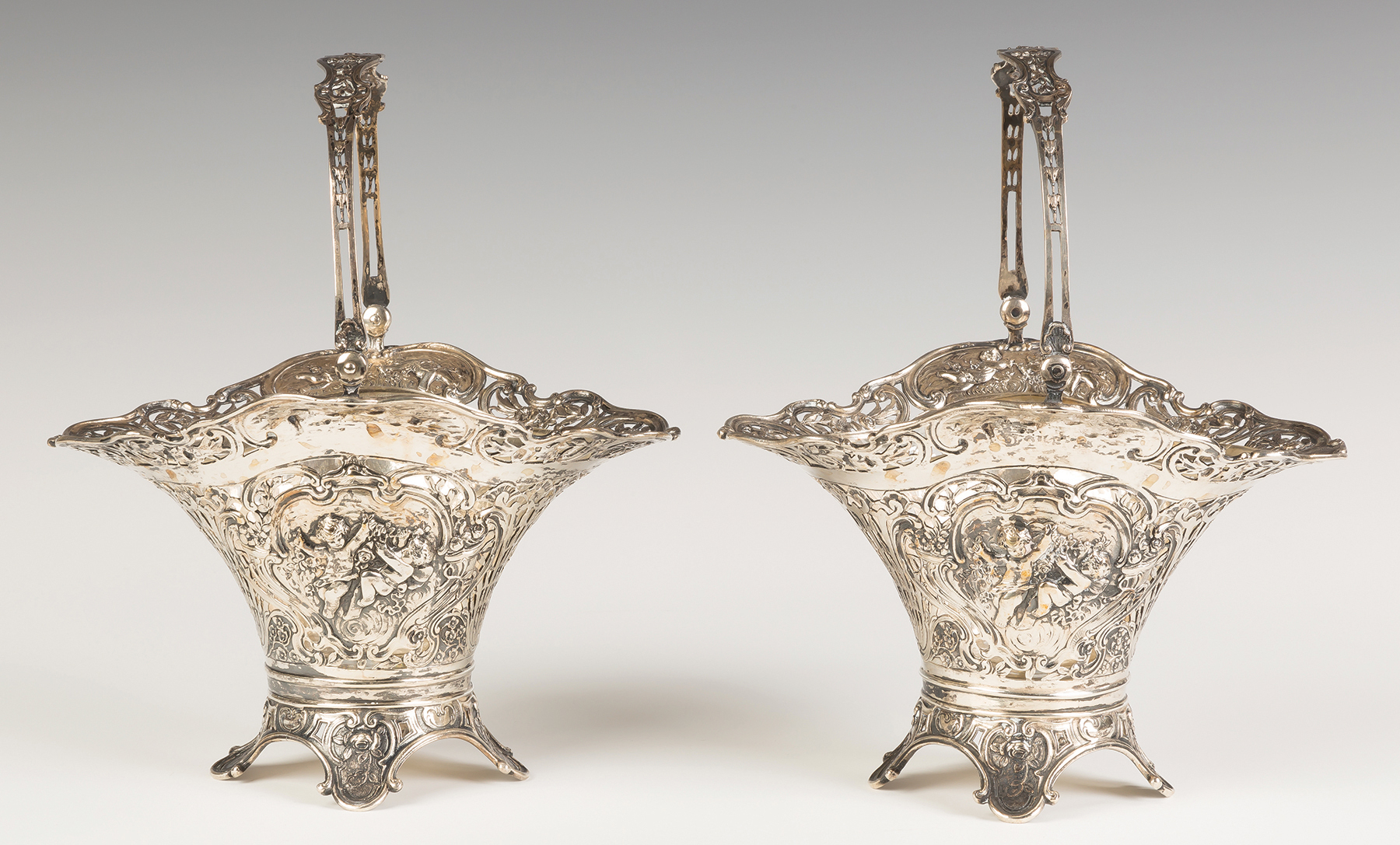 Appraisal: Silver Reticulated Baskets with Cherubs and Glass Liners Continental silver