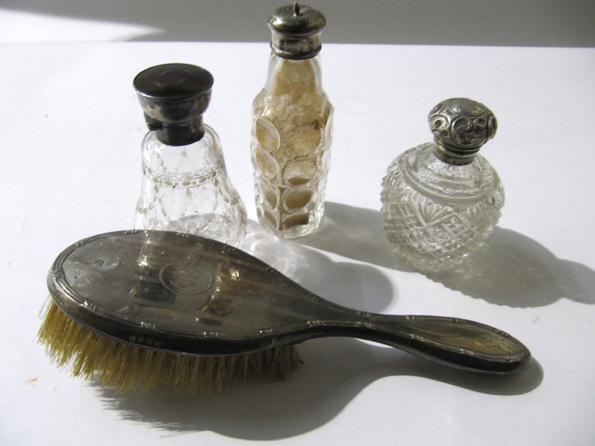 Appraisal: A lot comprising a silver brush two scent bottles and