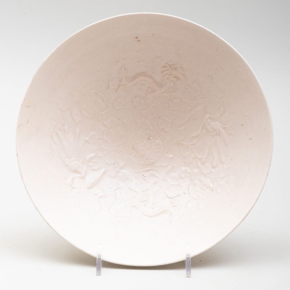 Appraisal: Chinese White Glazed Porcelain Bowl Molded with Dragons and Phoenix