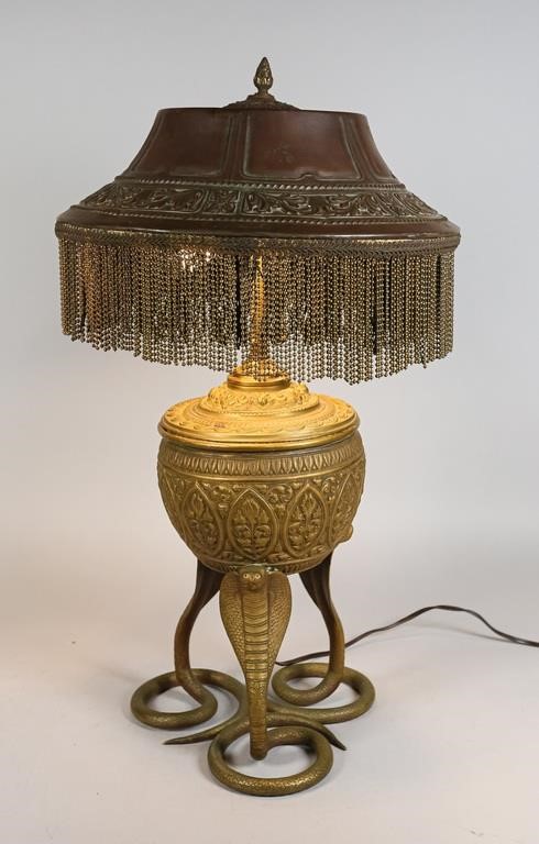 Appraisal: Gilt brass urn shaped lamp upon cast brass cobras Art