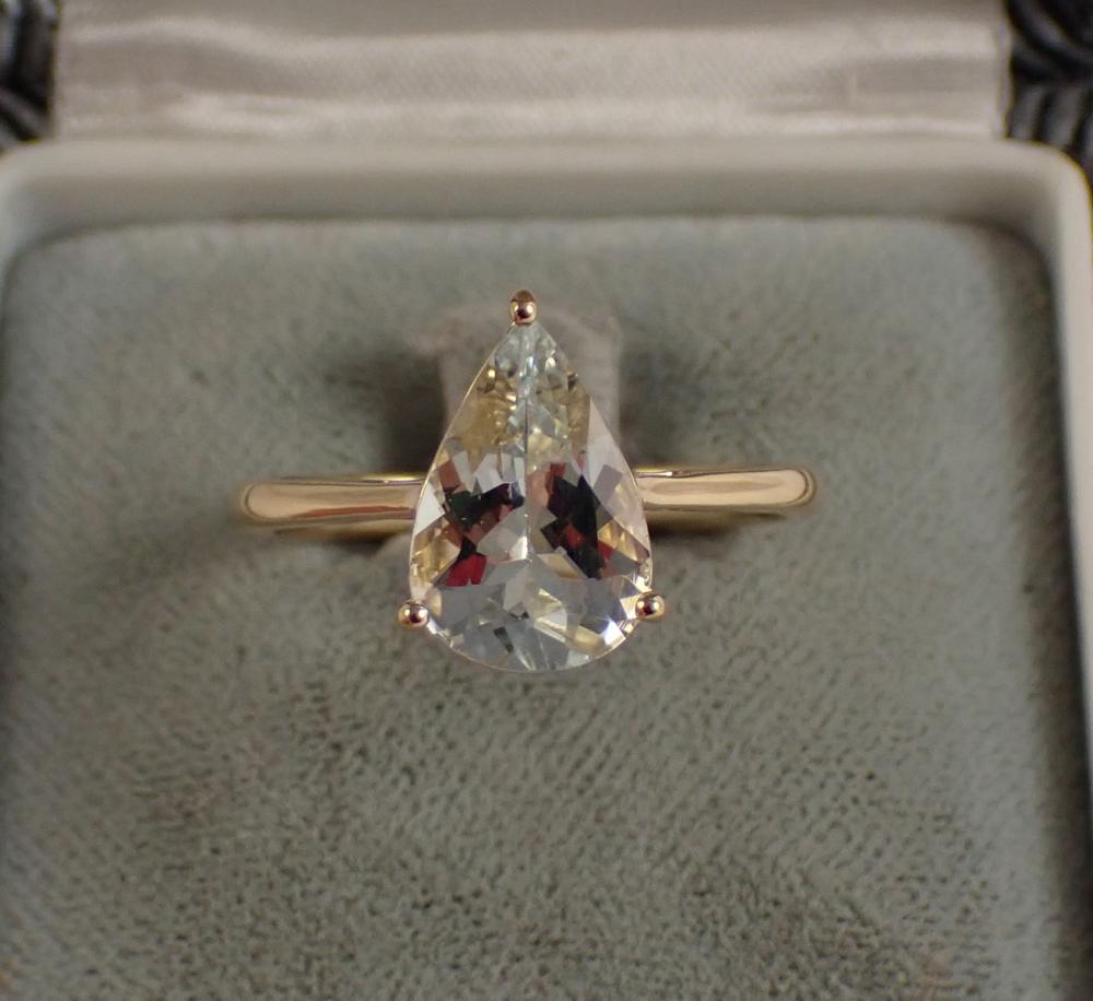 Appraisal: AQUAMARINE AND FOURTEEN KARAT GOLD SOLITAIRE RING with three yellow