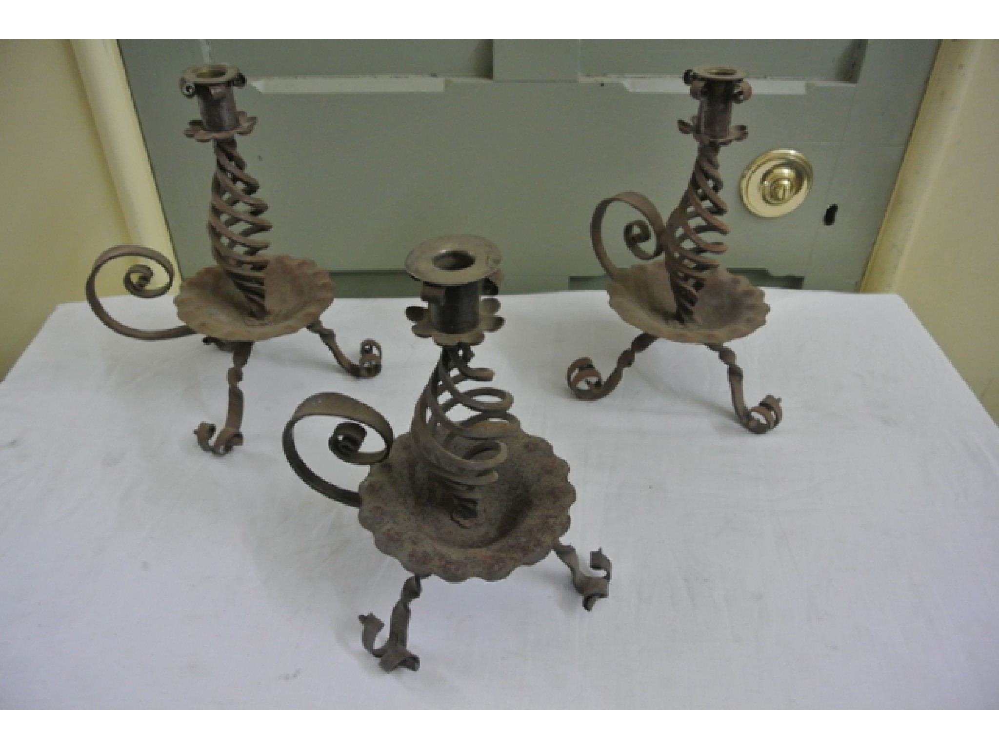 Appraisal: A pair of Arts and Crafts wrought iron candlesticks with