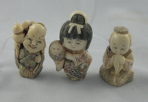 Appraisal: THREE ASIAN HAND CARVED IVORY NETSUKE young girl with doll