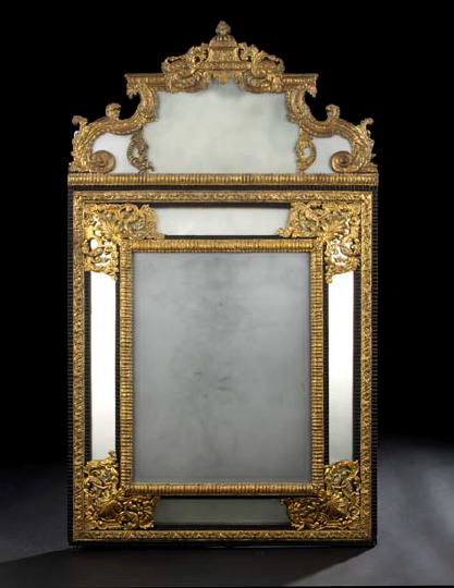 Appraisal: Dutch Embossed Gilt-Metal and Ebonized Cushion-Form Looking Glass late th