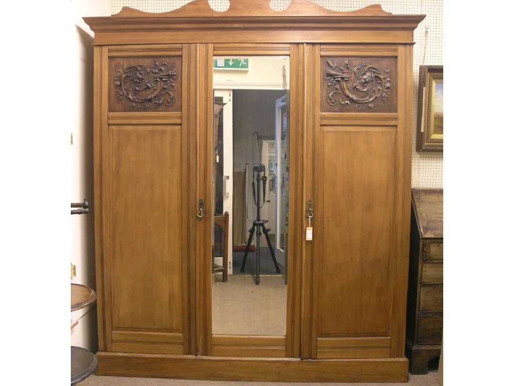 Appraisal: A late Victorian satin-walnut wardrobe arched pediment above a pair