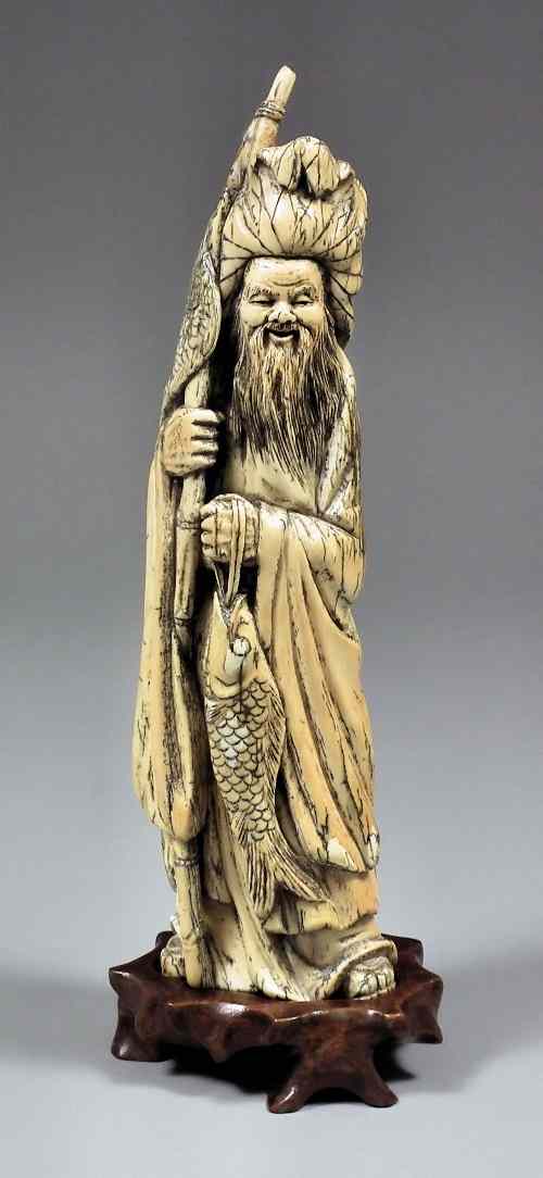 Appraisal: A Chinese carved ivory standing figure of a Sage carrying