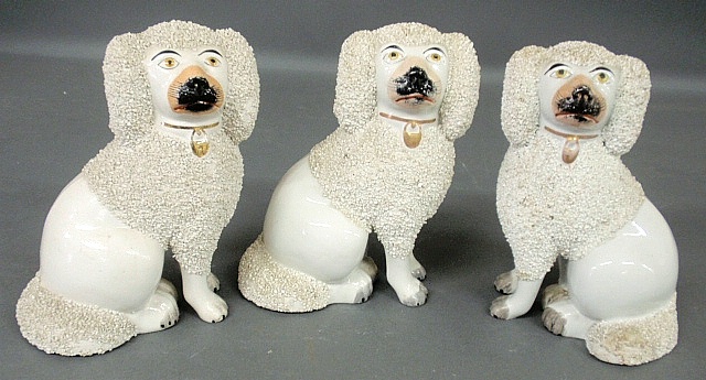 Appraisal: - Pair of Staffordshire seated white poodles c and another