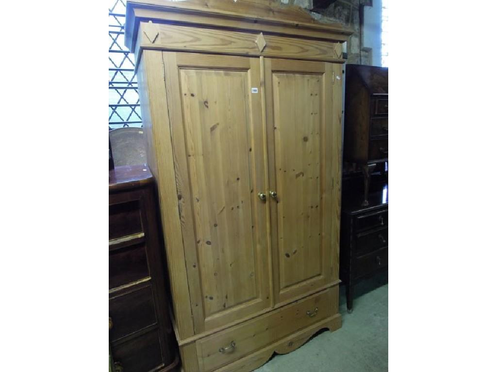 Appraisal: A stripped pine wardrobe with shaped pediment and moulded cornice