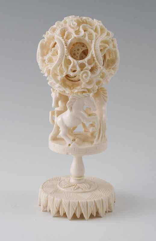 Appraisal: CARVED IVORY MYSTERY BALL ON HORSE STAND Carved and pierced