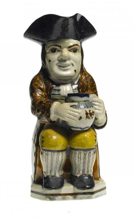 Appraisal: A PRATT-TYPE TOBY JUG the seated toper holding a large